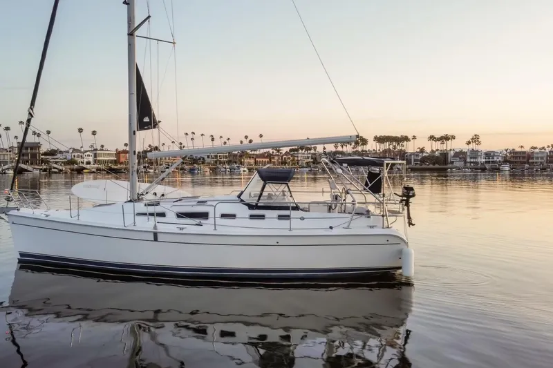 The Image of 2006 Hunter 38 sailboat docked in a serene marina at sunset. - 0