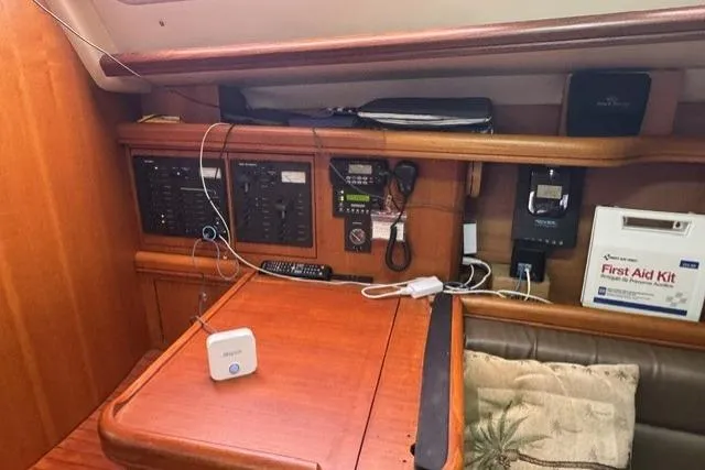 Slide: The Image of Navigation station inside a 2007 Hunter 38 sailboat with control panels and first aid kit. - 21