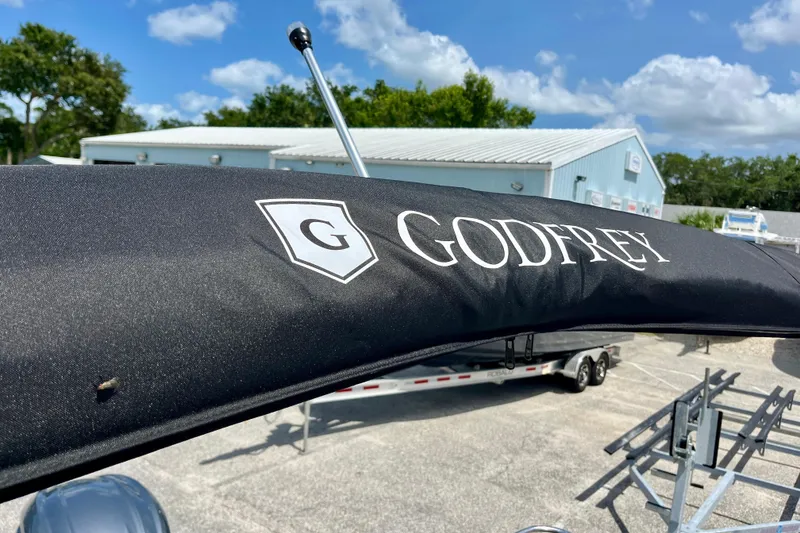 Slide: The Image of 2024 Godfrey Sweetwater 2286 SFL boat cover with logo, outdoor setting. - 20