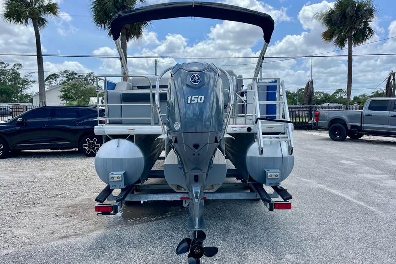 Slide: The Image of 2024 Godfrey Sweetwater 2286 SFL pontoon boat with Yamaha 150 engine, parked outdoors. - 4