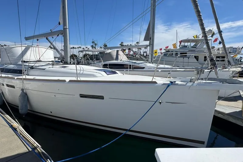 Slide: The Image of 2017 Jeanneau Sun Odyssey 449 sailboat docked at marina under clear blue sky. - 1