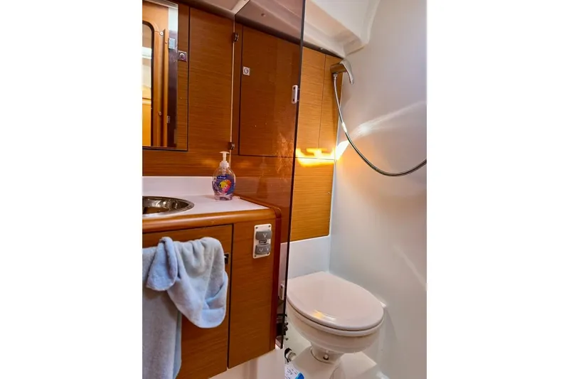 Slide: The Image of Bathroom interior of 2017 Jeanneau Sun Odyssey 449 yacht, featuring wooden cabinetry and modern fixtures. - 29