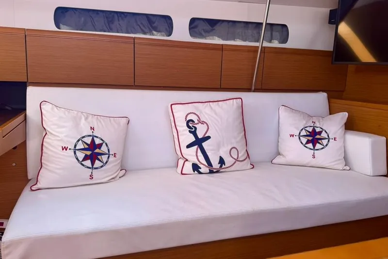 Slide: The Image of Interior of 2017 Jeanneau Sun Odyssey 449 with nautical-themed cushions on a white sofa. - 34