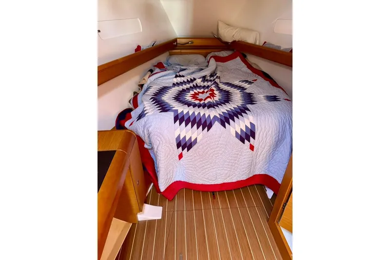 Slide: The Image of Cozy cabin interior of 2017 Jeanneau Sun Odyssey 449 with patterned quilt on bed. - 47