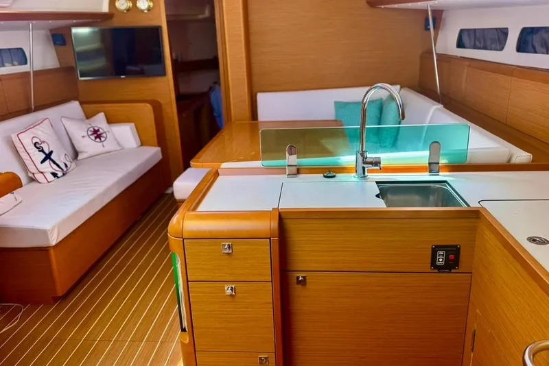 Slide: The Image of Interior of 2017 Jeanneau Sun Odyssey 449 yacht with modern kitchen and cozy seating area. - 56