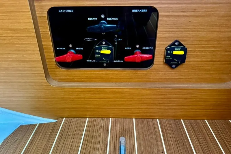 Slide: The Image of Electrical panel of a 2017 Jeanneau Sun Odyssey 449 sailboat, featuring battery and breaker controls. - 59