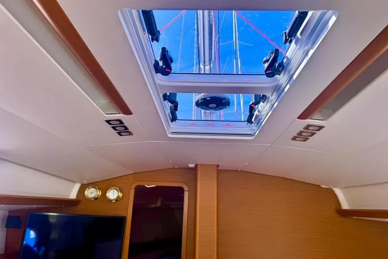 Slide: The Image of Interior view of 2017 Jeanneau Sun Odyssey 449 yacht with skylight and wooden accents. - 63