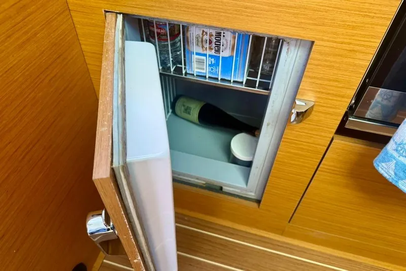 Slide: The Image of Open fridge on Jeanneau Sun Odyssey 449 yacht, showcasing interior storage space. - 65