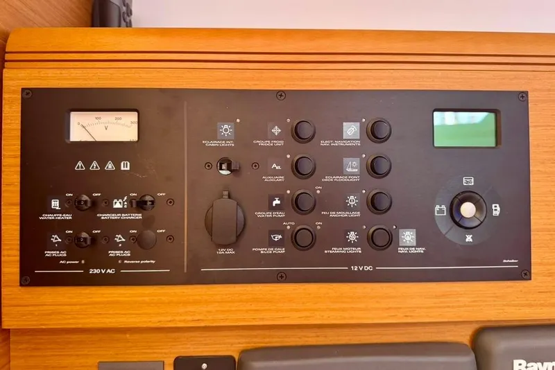 Slide: The Image of Control panel of a 2017 Jeanneau Sun Odyssey 449 sailboat, featuring various switches and gauges. - 67