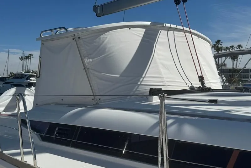 Slide: The Image of 2017 Jeanneau Sun Odyssey 449 sailboat with white canopy, docked under clear blue sky. - 7