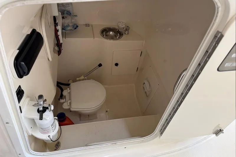 Slide: The Image of 2007 Pursuit C 310 Center Console boat interior with toilet and sink. - 17