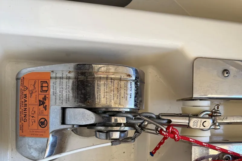 Slide: The Image of Anchor windlass on 2007 Pursuit C 310 Center Console boat with safety warning label. - 22