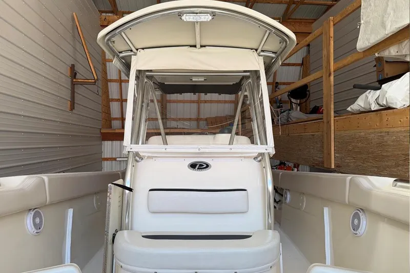 Slide: The Image of 2007 Pursuit C 310 Center Console boat in storage, showcasing helm and seating area. - 23