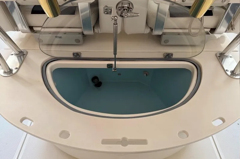 Slide: The Image of 2007 Pursuit C 310 Center Console boat's livewell with open lid and rod holders. - 25