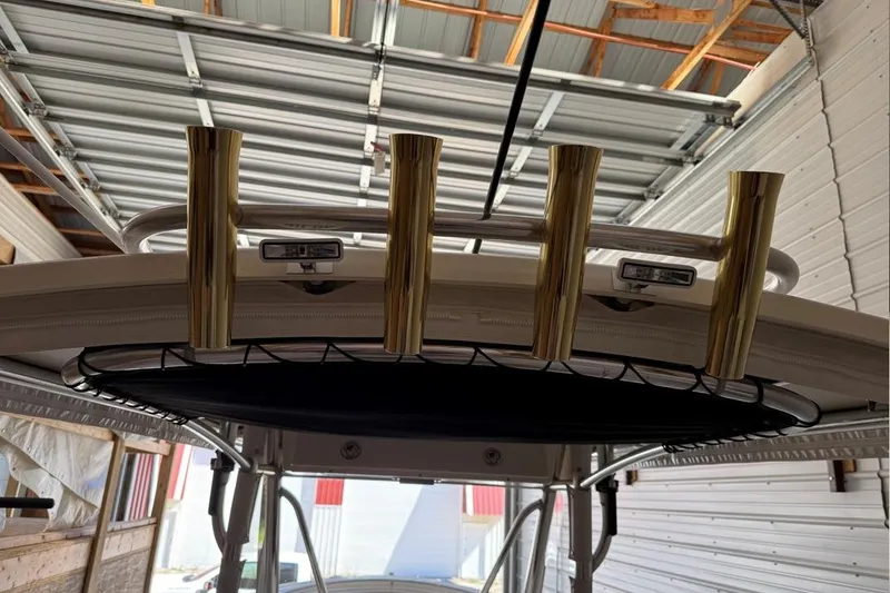 Slide: The Image of 2007 Pursuit C 310 Center Console boat with gold rod holders in a garage. - 27