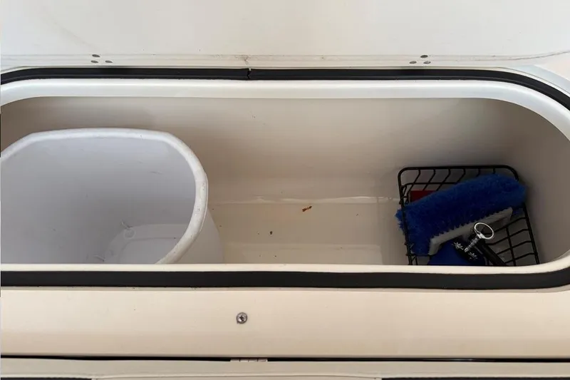 Slide: The Image of Storage compartment of a 2007 Pursuit C 310 Center Console boat with cleaning supplies. - 30