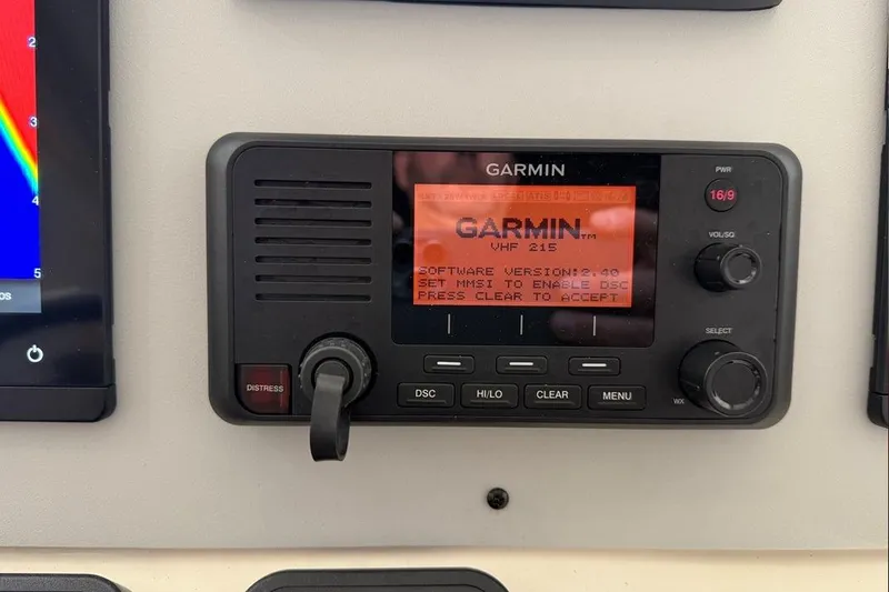 Slide: The Image of Garmin VHF 215 radio on 2007 Pursuit C 310 Center Console boat dashboard. - 35