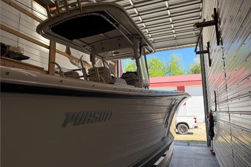 Slide: The Image of 2007 Pursuit C 310 Center Console boat in a garage, side view. - 47