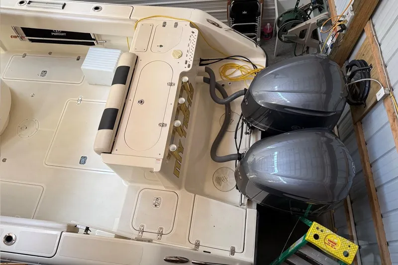 Slide: The Image of 2007 Pursuit C 310 Center Console boat with dual outboard motors in a storage area. - 49