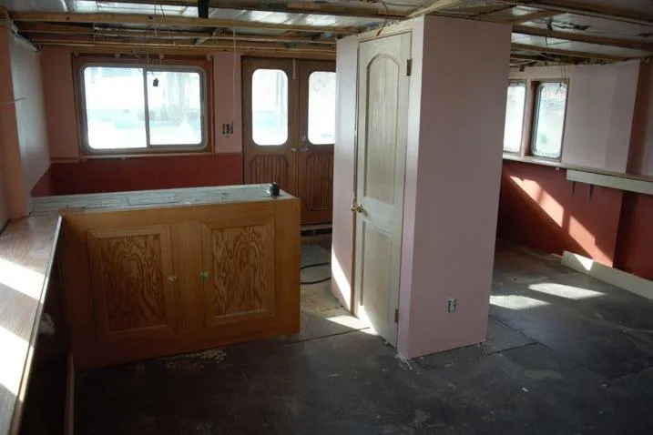 Slide: The Image of Interior of a 1977 Commercial Expedition Trawler with wooden cabinetry and pink walls. - 11