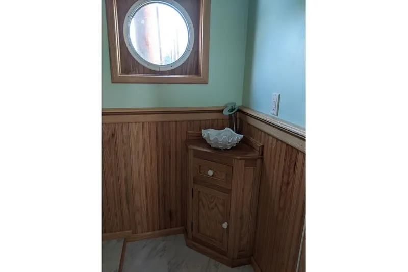 Slide: The Image of Wood-paneled bathroom corner with porthole window on 1977 Commercial Expedition Trawler. - 14