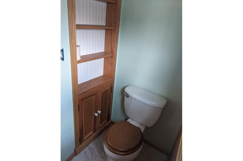 Slide: The Image of Small bathroom with wooden shelving and toilet in a 1977 Commercial Expedition Trawler. - 15