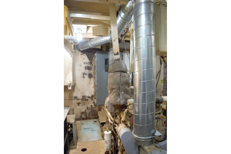 Slide: The Image of Engine room of a 1977 Commercial Expedition Trawler with visible ductwork and machinery. - 23