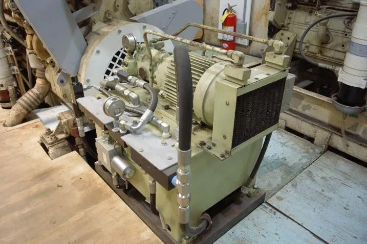 Slide: The Image of Engine room machinery of a 1977 Commercial Expedition Trawler, featuring hydraulic components and motor. - 25
