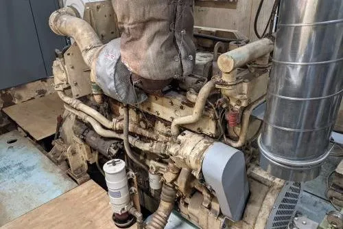 Slide: The Image of Engine room of a 1977 Commercial Expedition Trawler, showcasing complex machinery and piping. - 28