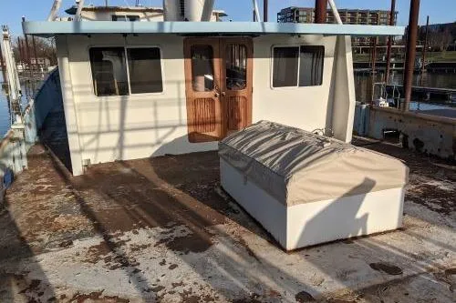 Slide: The Image of 1977 Commercial Expedition Trawler with weathered deck and cabin, docked at a marina. - 7