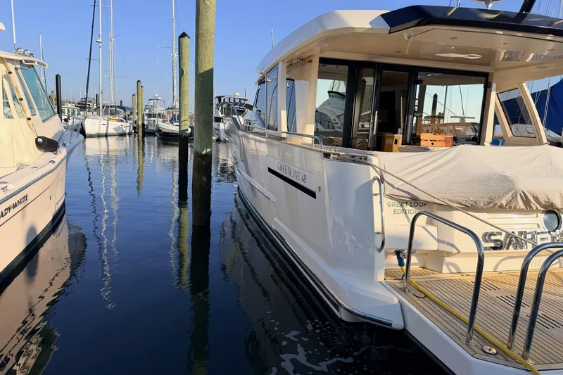 Slide: The Image of 2019 Greenline 48 Coupe yacht docked in a marina, surrounded by other boats. - 3