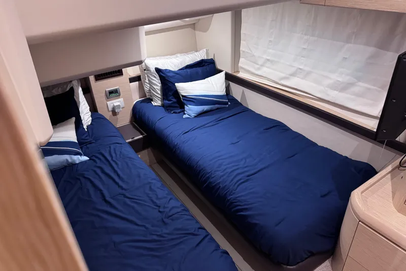 Slide: The Image of Interior of 2019 Greenline 48 Coupe yacht with twin beds and blue bedding. - 35