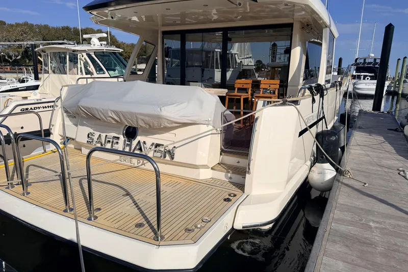 Slide: The Image of 2019 Greenline 48 Coupe yacht docked, featuring spacious deck and seating area. - 4