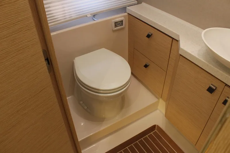 Slide: The Image of Interior of 2019 Greenline 48 Coupe with toilet and wooden cabinets. - 49