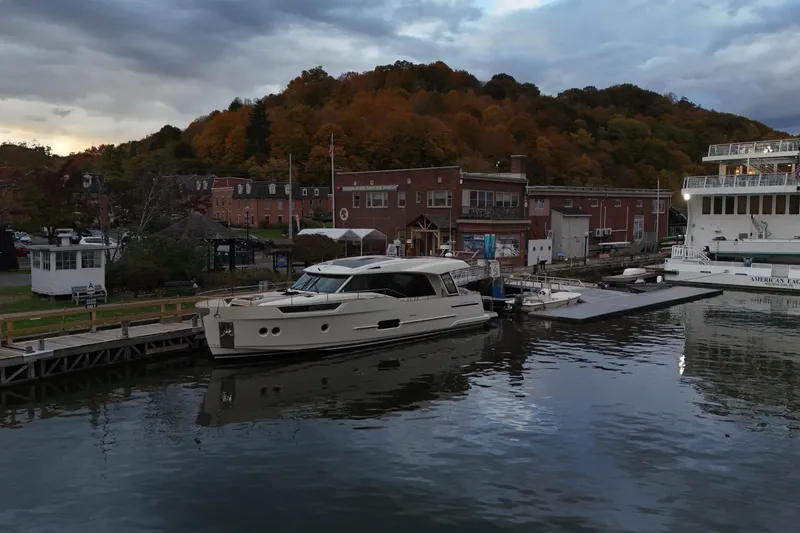 Slide: The Image of 2019 Greenline 48 Coupe docked by autumnal hillside and historic buildings. - 6