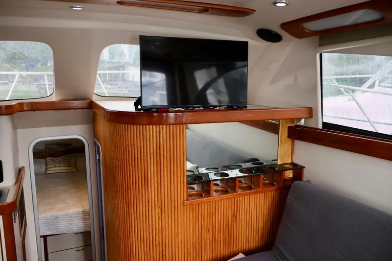 Slide: The Image of Interior of 1994 Luhrs 32 Convertible yacht with TV and wooden cabinetry. - 40