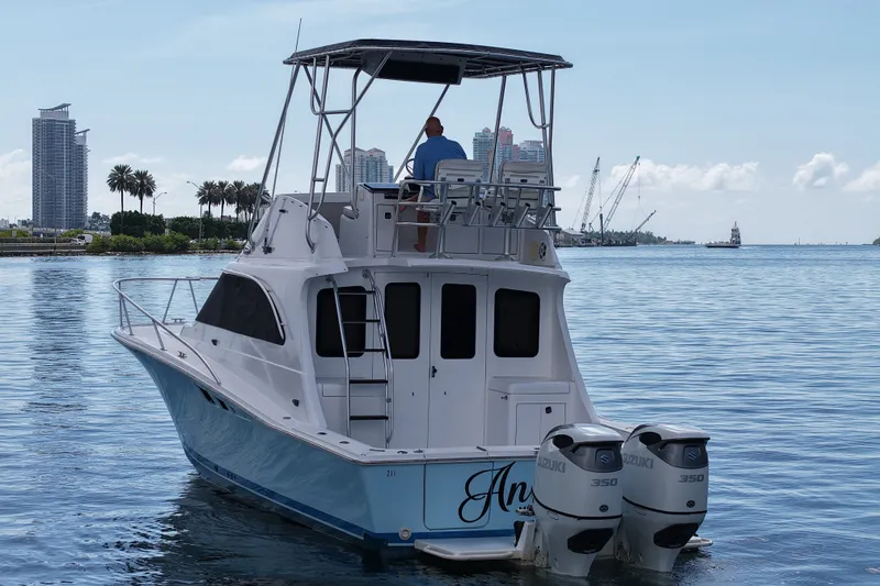 Slide: The Image of 1994 Luhrs 32 Convertible boat with dual Suzuki 350 engines on calm water. - 52