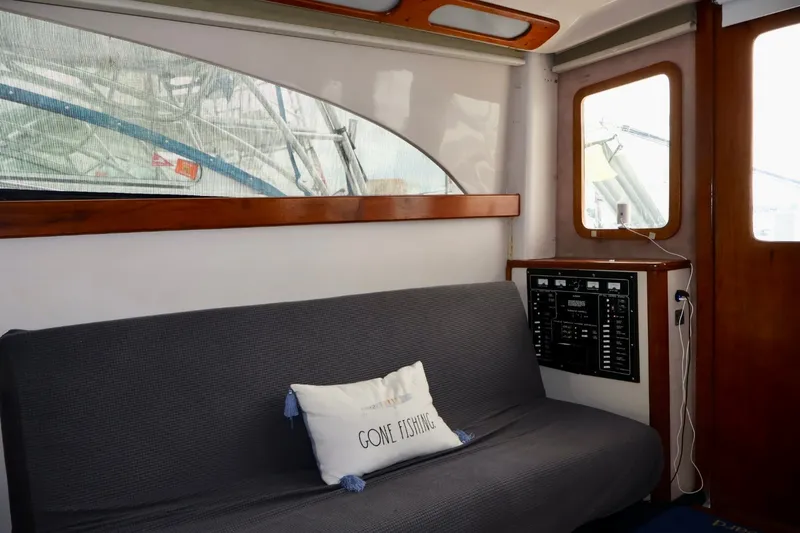 Slide: The Image of Interior of 1994 Luhrs 32 Convertible boat with sofa and "Gone Fishing" pillow. - 59