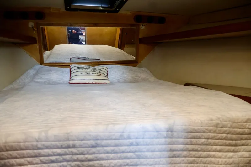 Slide: The Image of 1994 Luhrs 32 Convertible cabin interior with bed and decorative pillow. - 64