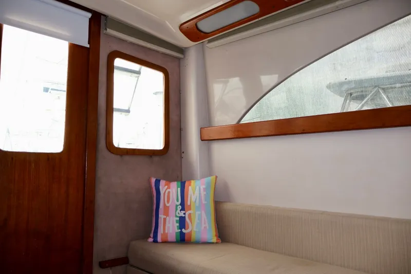 Slide: The Image of Interior of 1994 Luhrs 32 Convertible boat with colorful pillow on beige seating. - 58