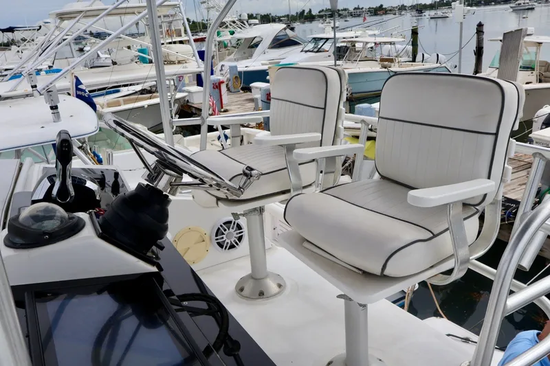 Slide: The Image of 1994 Luhrs 32 Convertible boat helm with dual captain chairs at marina. - 55