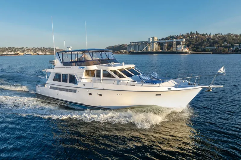The Image of 1991 Tollycraft 57 Pilothouse Motor Yacht cruising on a sunny day near industrial waterfront. - 1