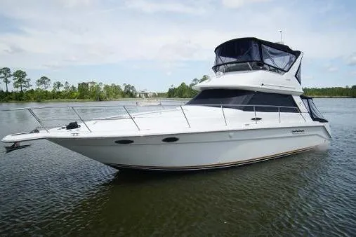 The Image of 1996 Sea Ray 370 Sedan Bridge yacht on calm water, showcasing sleek design and spacious deck. - 0