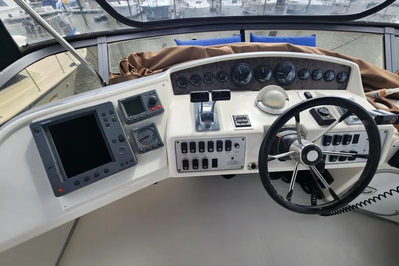 Slide: The Image of 1996 Sea Ray 370 Sedan Bridge helm with navigation instruments and steering wheel. - 11