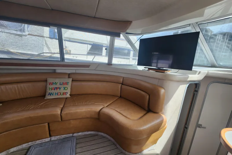 Slide: The Image of Interior of 1996 Sea Ray 370 Sedan Bridge with leather seating and TV. - 17