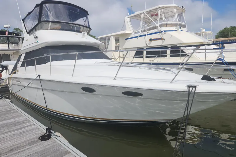 Slide: The Image of 1996 Sea Ray 370 Sedan Bridge yacht docked at marina, side view. - 2