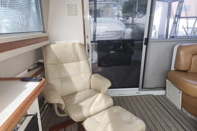Slide: The Image of Interior of 1996 Sea Ray 370 Sedan Bridge with beige leather chair and sliding glass door. - 20