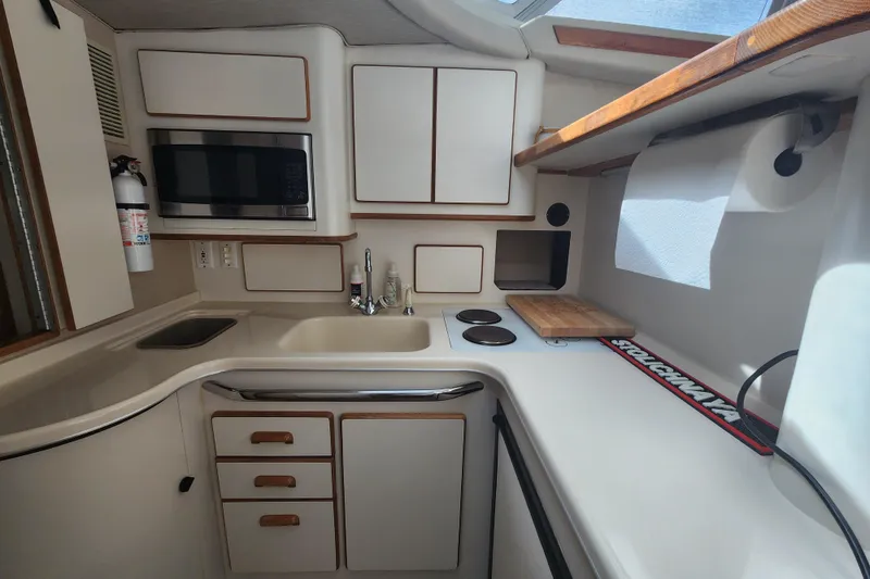 Slide: The Image of Compact kitchen in a 1996 Sea Ray 370 Sedan Bridge yacht with modern amenities. - 27