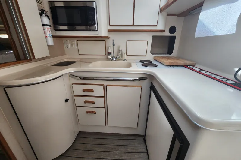 Slide: The Image of Compact kitchen in a 1996 Sea Ray 370 Sedan Bridge yacht, featuring modern appliances. - 28