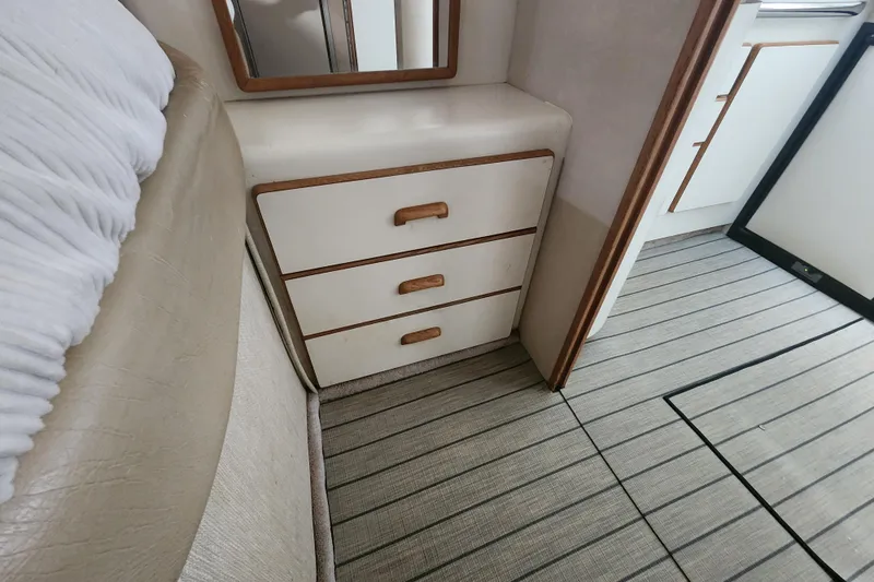 Slide: The Image of Interior of 1996 Sea Ray 370 Sedan Bridge with wooden drawers and striped flooring. - 35